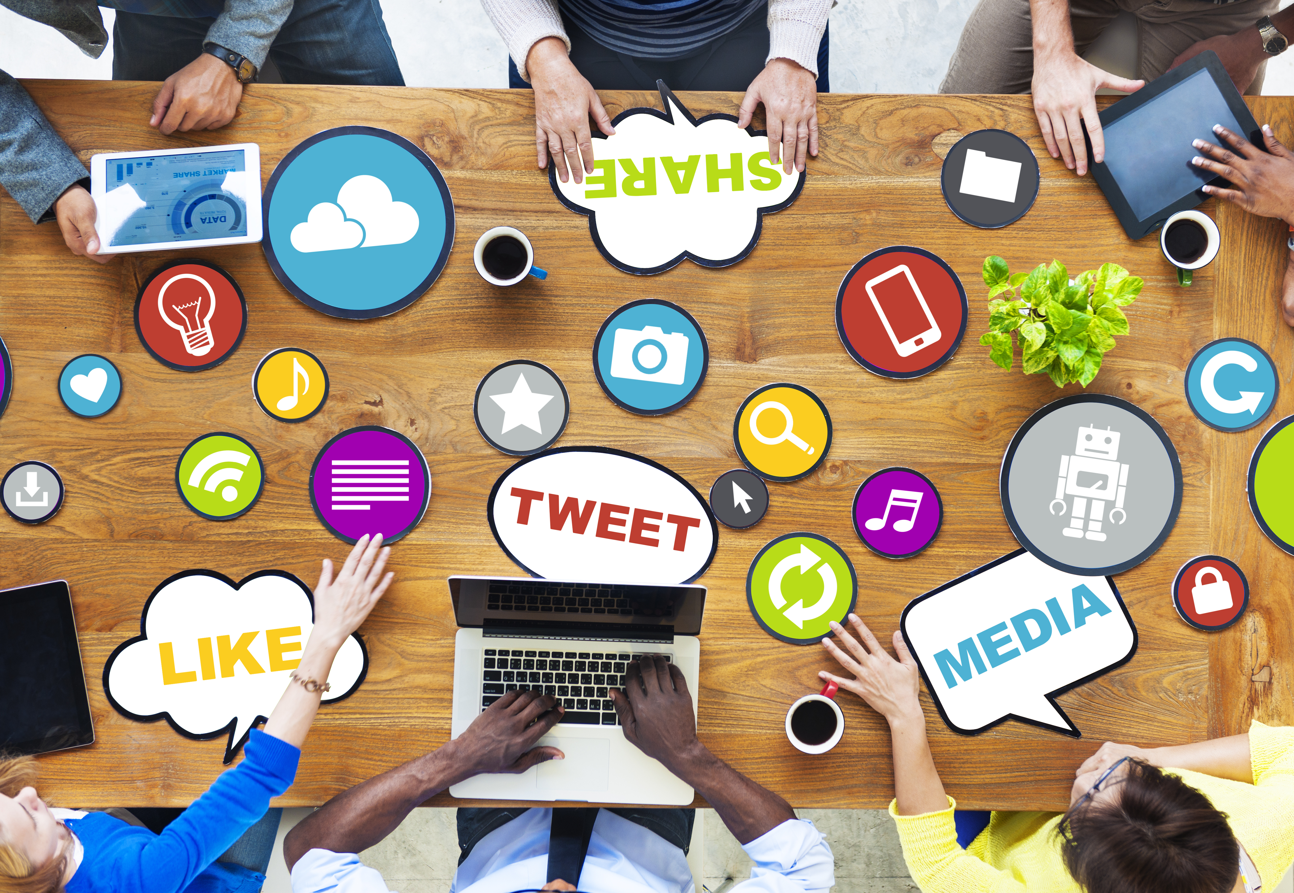 People discussing social media at a desk with scattered media icons